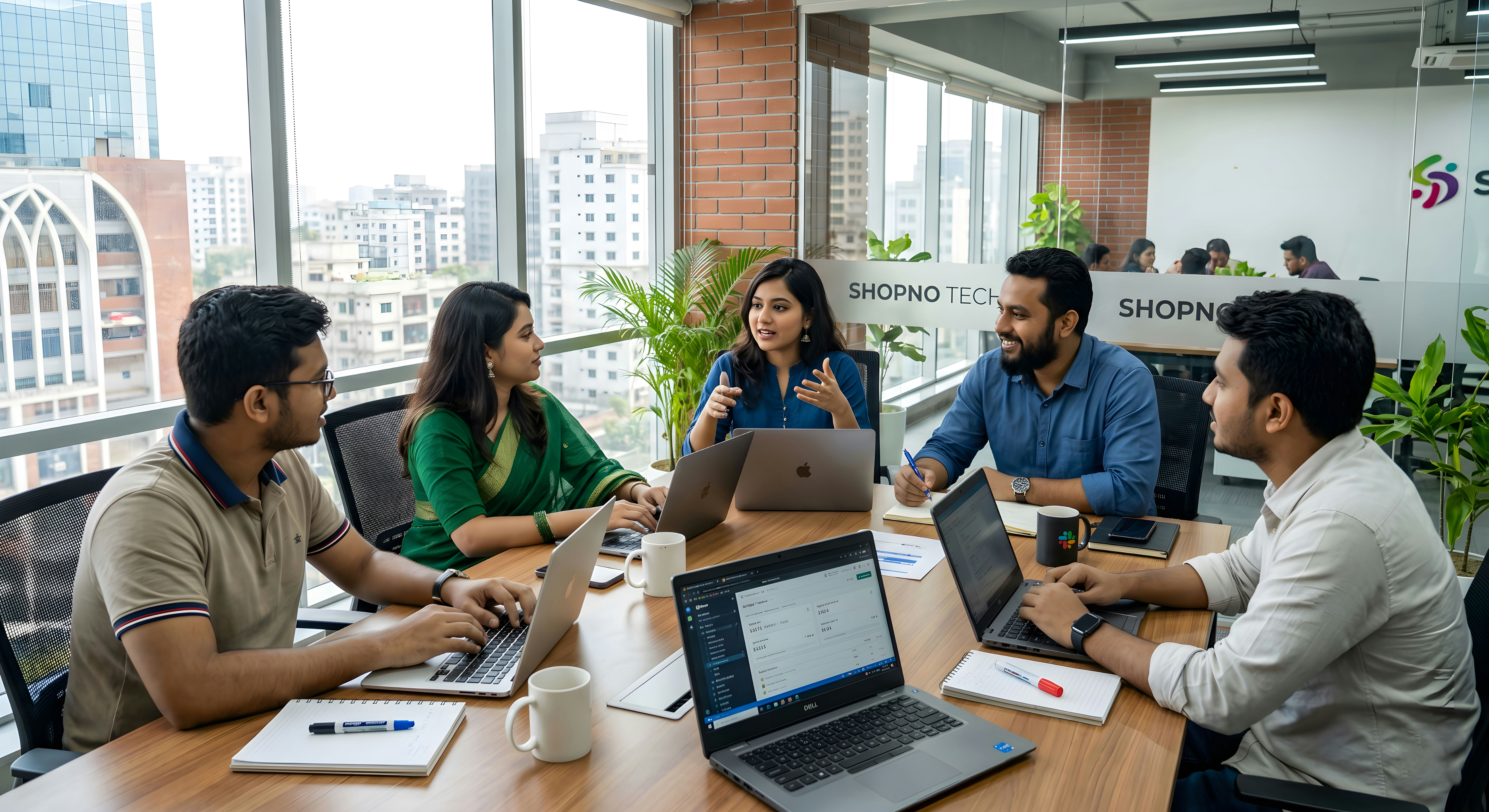 A diverse Bangladeshi startup team collaborating around a conference table in a modern Dhaka office. Young professionals working together on laptops during a strategy meeting, showcasing teamwork, innovation, entrepreneurship, and digital business culture in Bangladesh. Natural sunlight, authentic workplace atmosphere, and professional corporate environment.